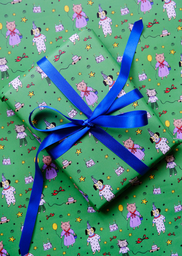 Gift box with blue ribbon on a green background with cartoon characters dog and cat hand illustrated